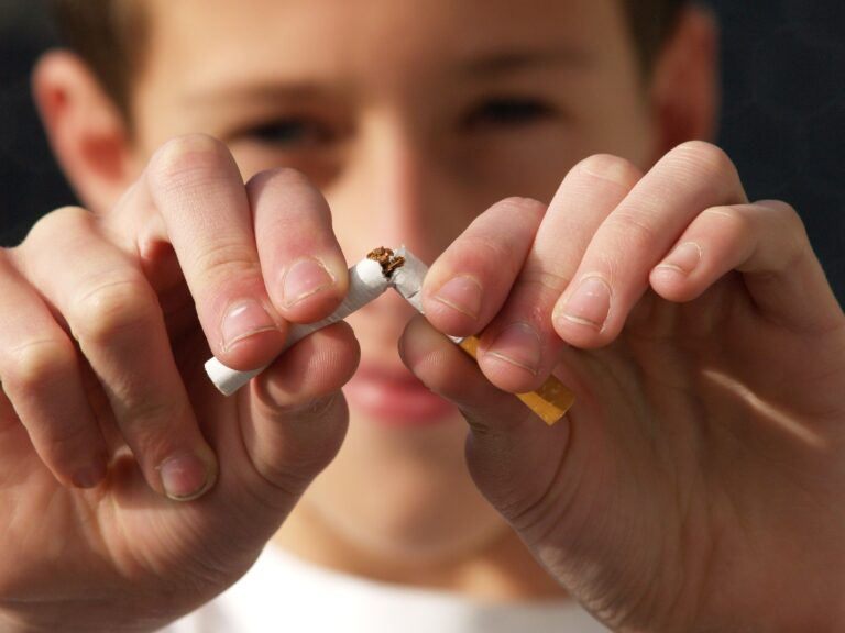 A person snapping a cigarette in half